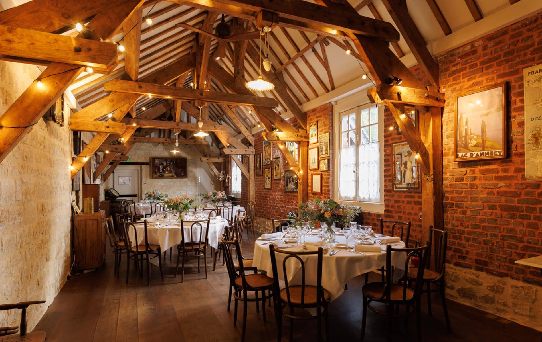 Salle de restaurant du Château de la Tour avec poutres apparentes et murs en briques